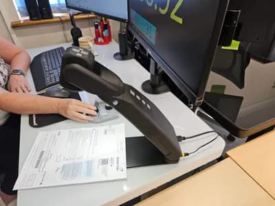 Close-up of Helix Pro articulating arm showing tactile control buttons and camera head with document underneath